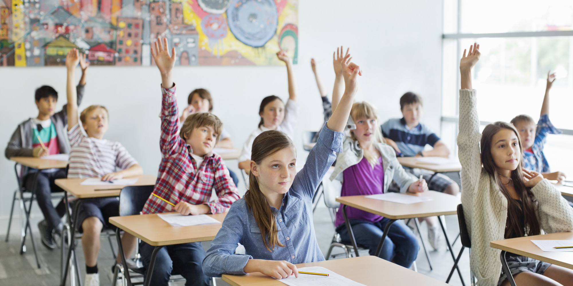 Students with arms raised in classroom